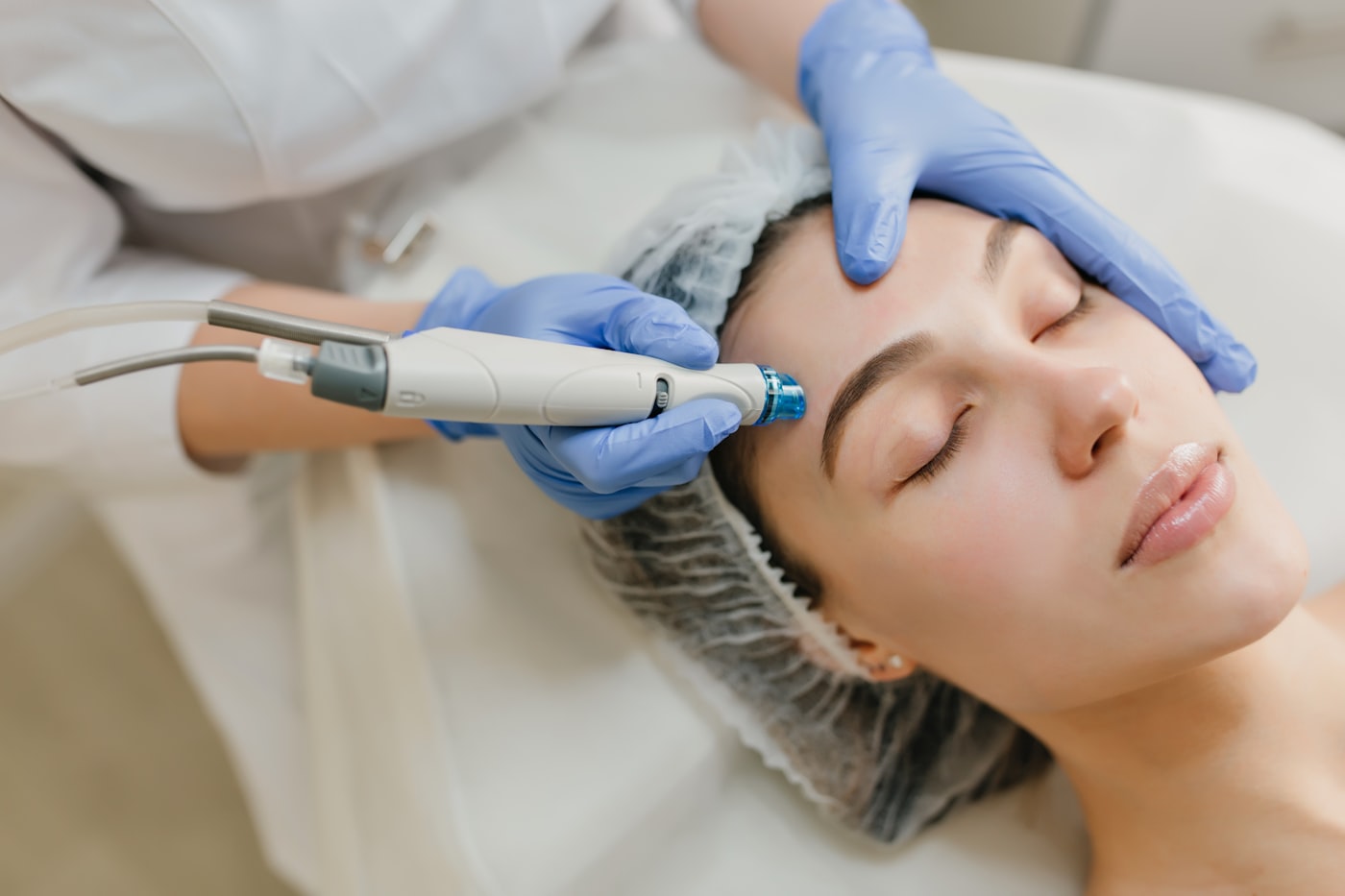 A clinician performing a facial skin treatment on a patient