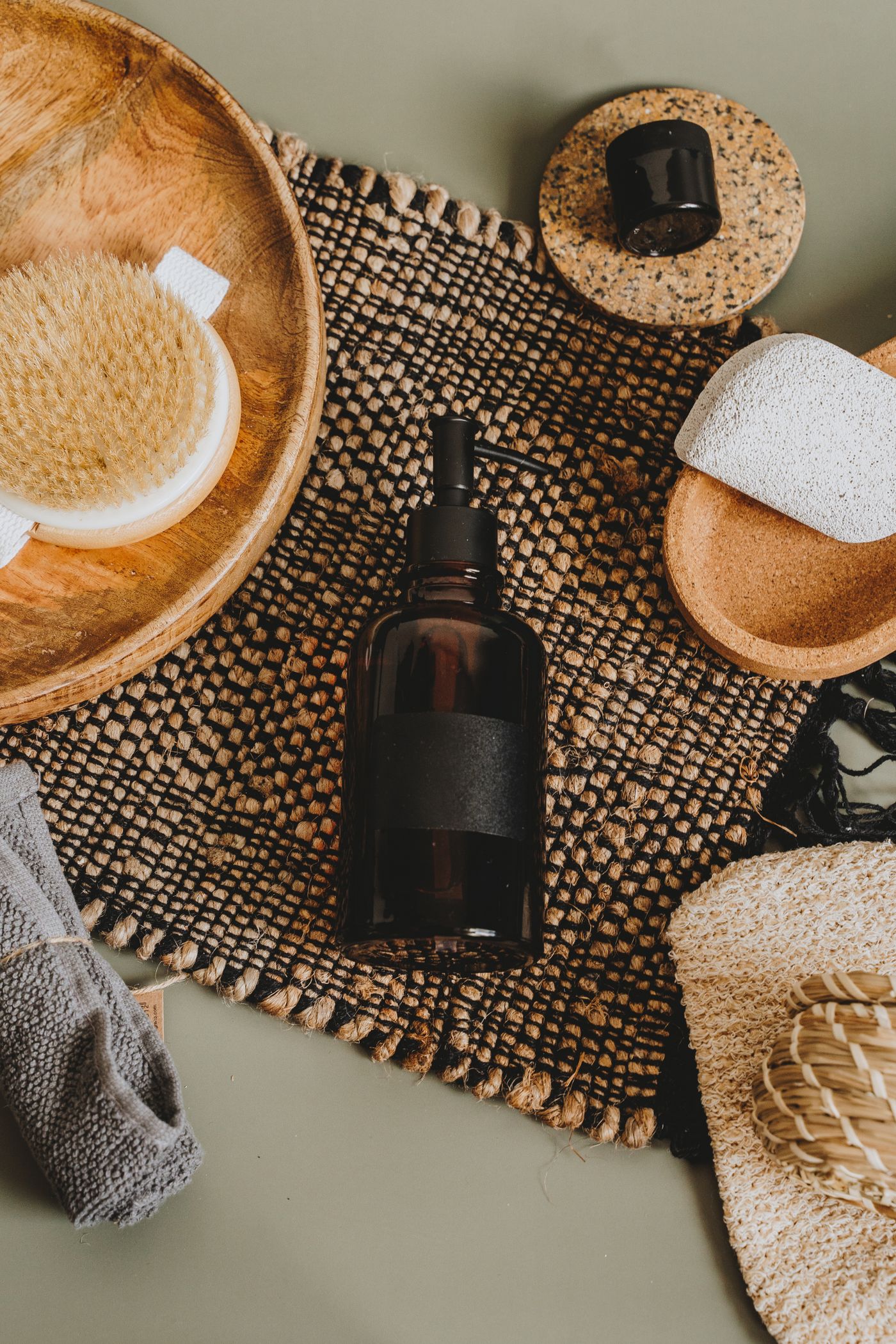An unlabeled pump bottle styled with natural spa accessories